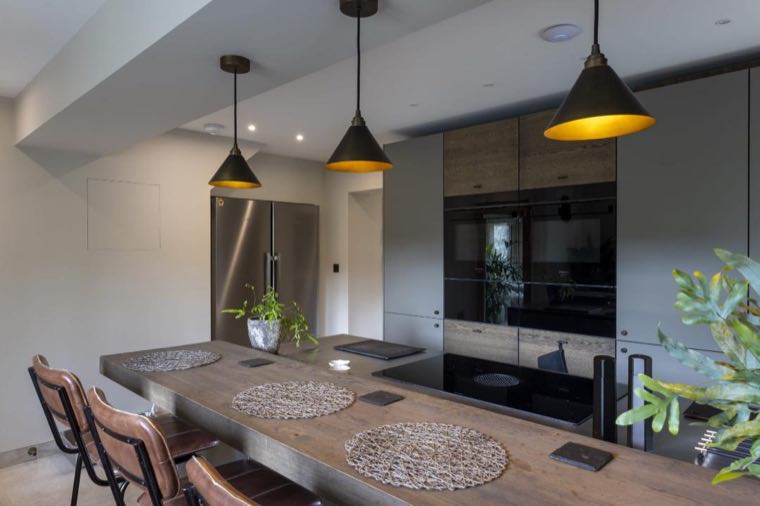 Oak breakfast bar and black gloss ovens